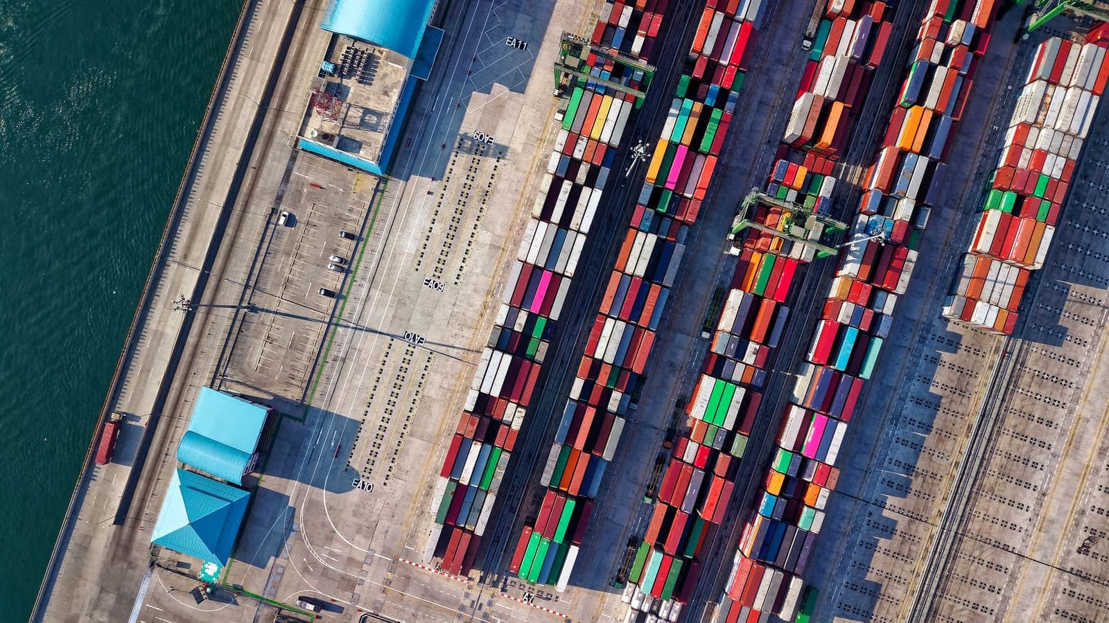 Aerial view of thousands of shipping containers stacked in rows at a port terminal